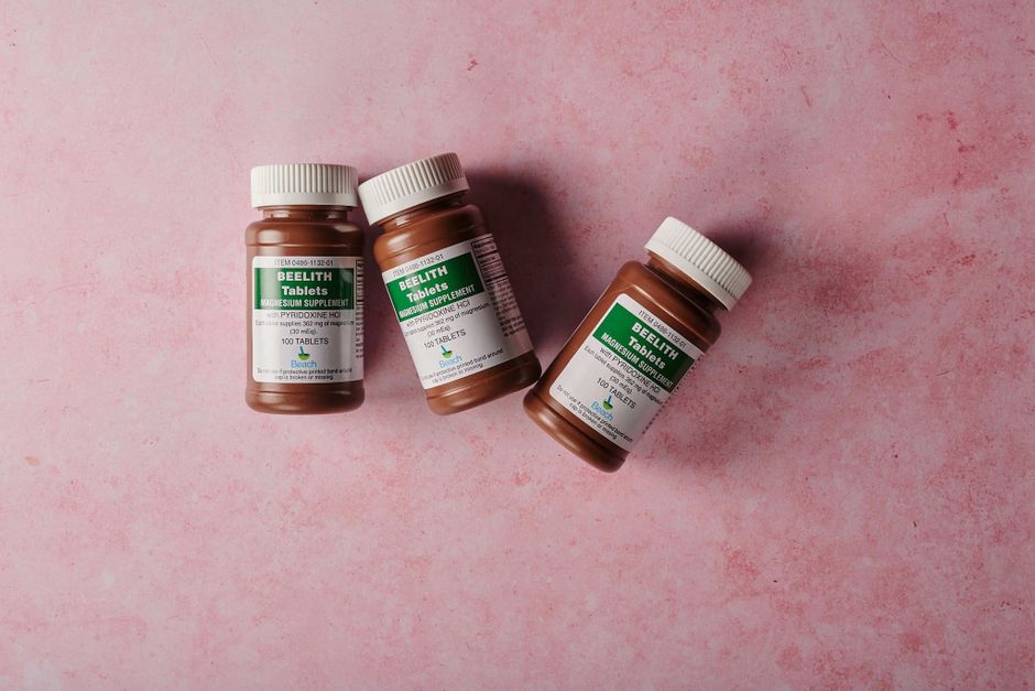 Een persoon die magnesium supplementen in poeder en capsulevorm gebruikt voor betere gezondheid en energieniveaus.